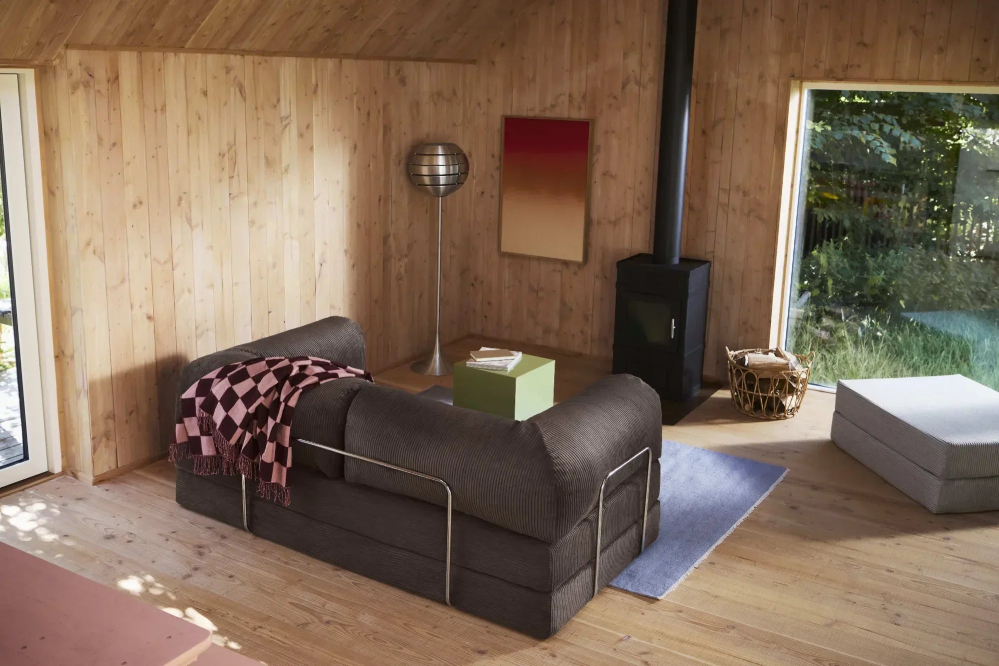 A minimalist modular  in a Scandinavian wooden cabin setting with natural daylight and warm wood paneling.